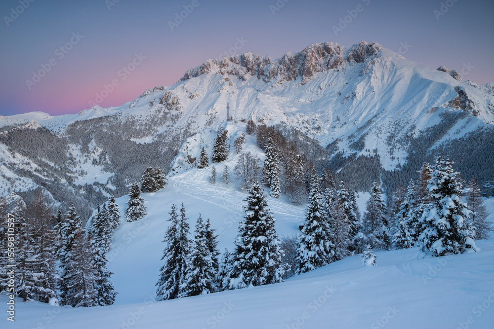 Sunrise in the mountains Winter landscape with snowy peaks and trees, Italian Alps, Lombardy, Italy.