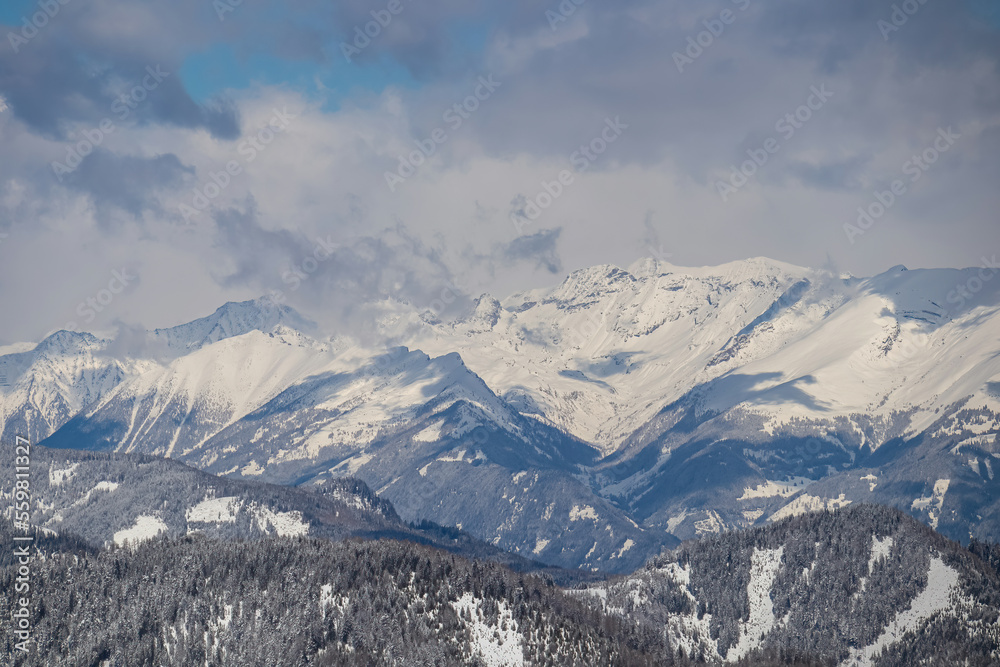 Panoramic view of the snowcapped mountain ranges of High Tauern and Nock Mountains seen from Kobesnock near Bad Bleiberg, Carinthia, Austria, Europe. Winter wonderland landscape in Austrian Alps