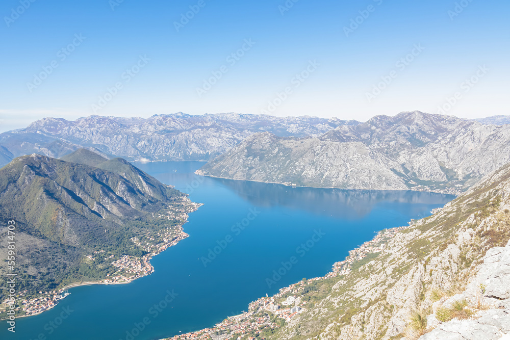 Obraz premium Panoramic view from Derinski Vrh (Pestingrad) of Kotor bay on sunny summer day, Adriatic Mediterranean Sea, Montenegro, Balkan, Europe. Fjord winding along coastal towns. Lovcen, Orjen mountain range