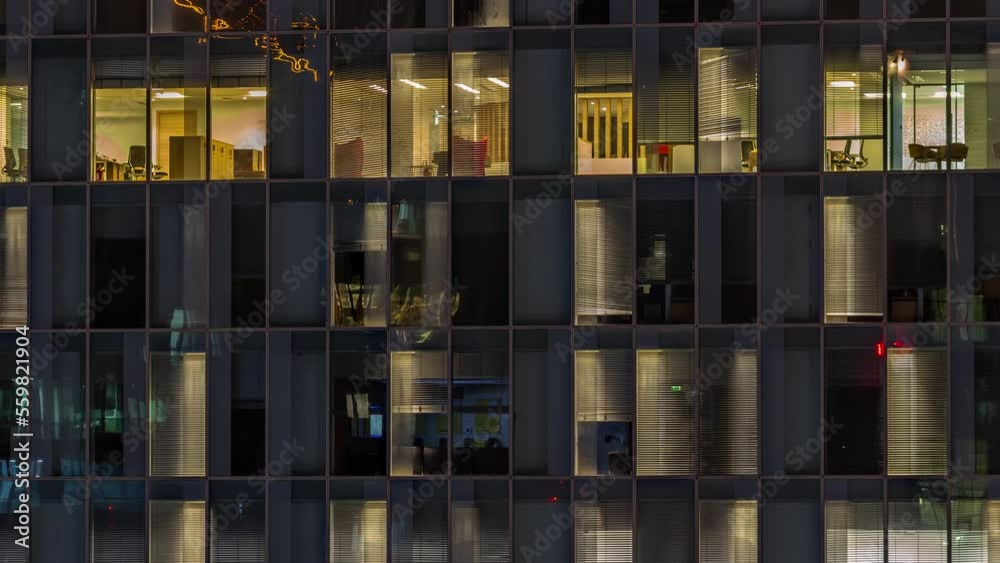 Night aerial view of office building glass window facade with illuminated lighted workspace rooms timelapse. Glowing and blinking light in skyscraper Night aerial view of office building glass window facade with illuminated lighted workspace rooms timelapse. Glowing and blinking light in skyscraper