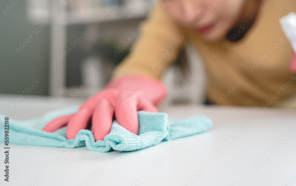 happy Female housekeeper service worker wiping table surface by cleaner product to clean dust.