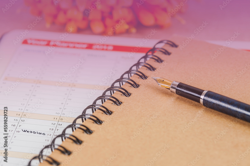 word wedding on calendar with sweet flowers and pen ,love concept. word wedding on calendar with sweet flowers and pen ,love concept.