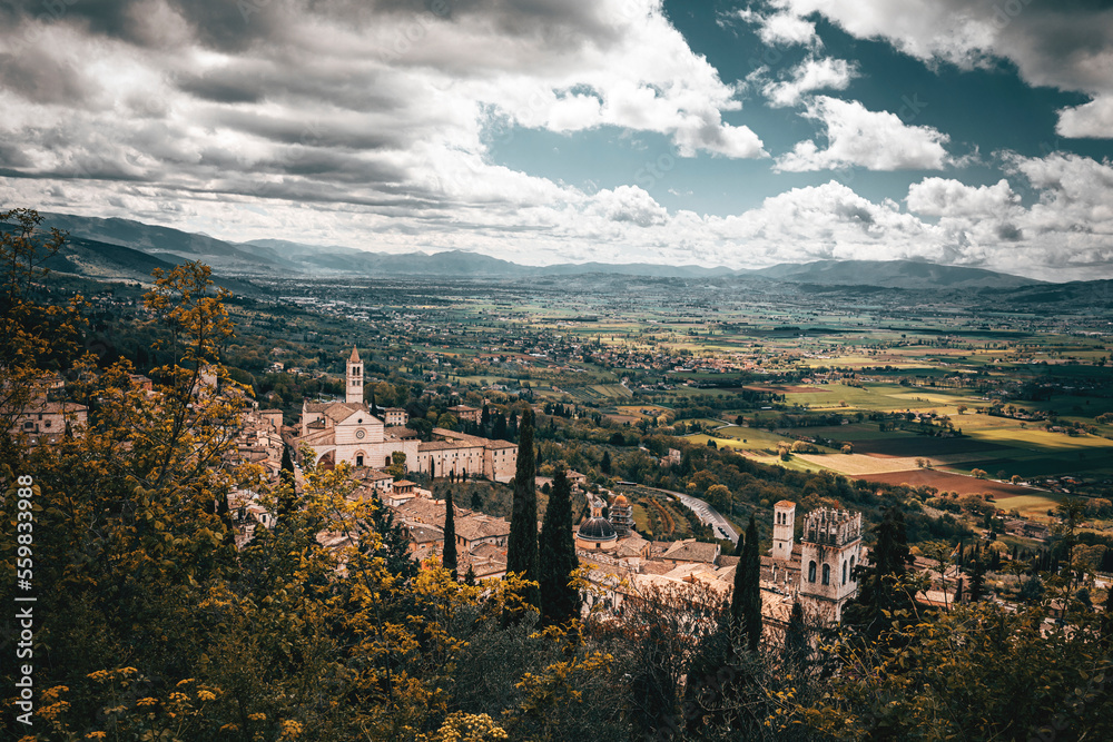 panorama of the town of assisi in italy on a spring cloudy day wth village and church view