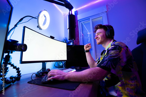 Cheerful man playing computer game photo