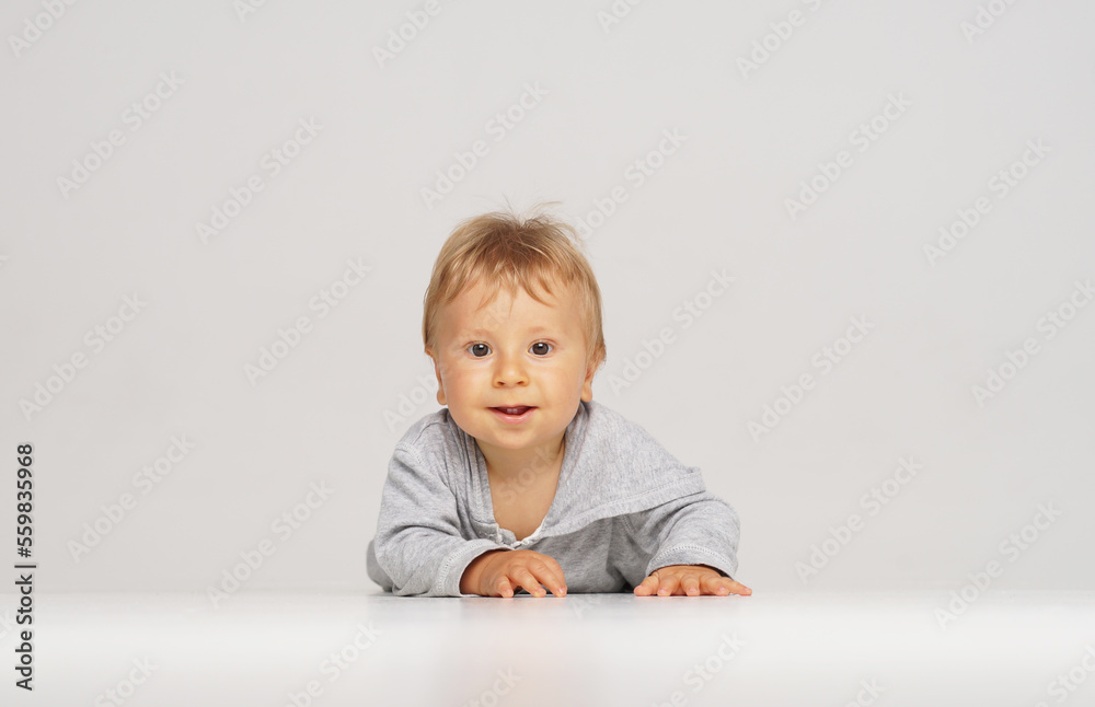 Little, happy and smiling cute baby in the studio. Portrait of a one year old baby. The concept of happiness. Little, happy and smiling cute baby in the studio. Portrait of a one year old baby. The concept of happiness.