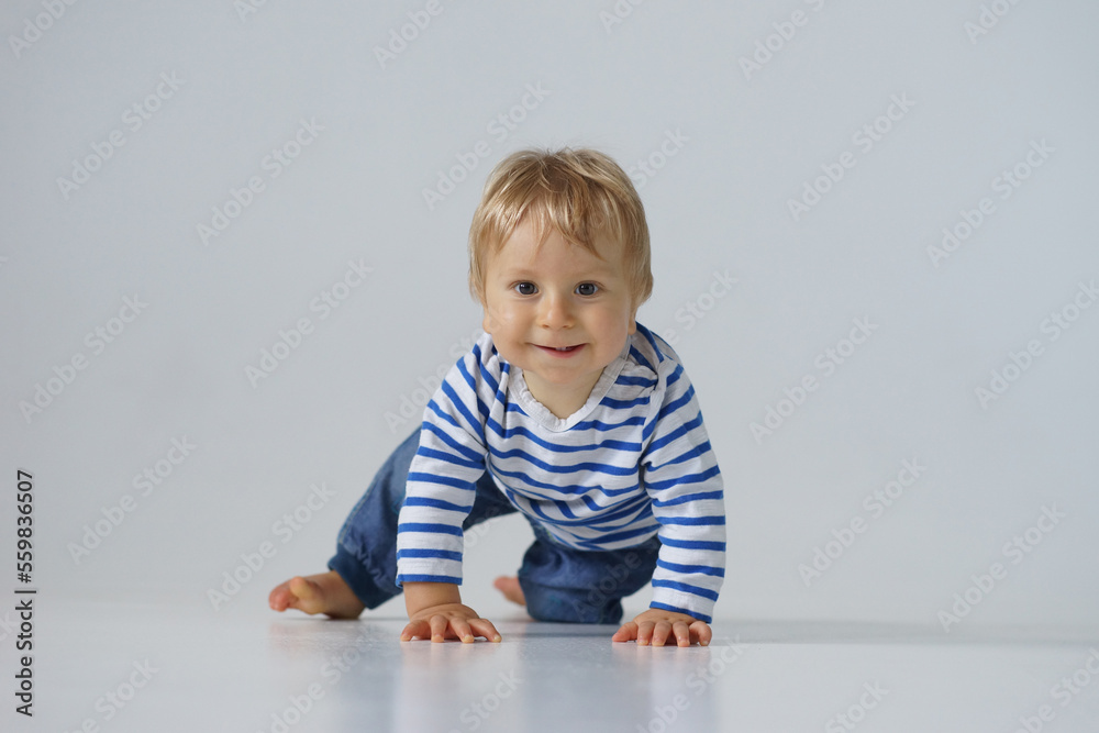 Little, happy and smiling cute baby in the studio. Portrait of a one year old baby. The concept of happiness. Little, happy and smiling cute baby in the studio. Portrait of a one year old baby. The concept of happiness.