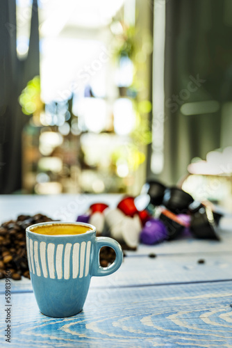 A small blue porcelain espresso cup on a table near the window