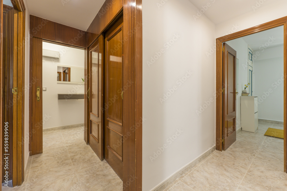 Distributor corridor of a house with access to various substances through sapele doors and stoneware floors Distributor corridor of a house with access to various substances through sapele doors and stoneware floors