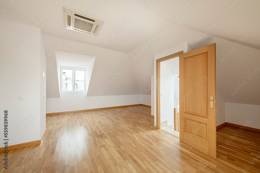 Spacious room in the attic floor of a single-family home with skylights, oak flooring, air conditioning on the ceiling and aluminum radiators - obrazy, fototapety, plakaty 