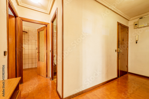 Entrance hall of a house with access to several rooms through sapele doors and orange stoneware floors