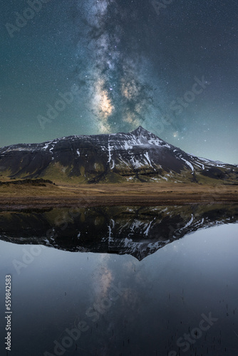 Majestic mountains of East Fjords in Iceland near lake under starry sky at night