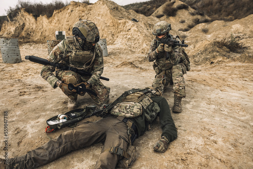 Fotografie Soldiers near the wounded man examining him