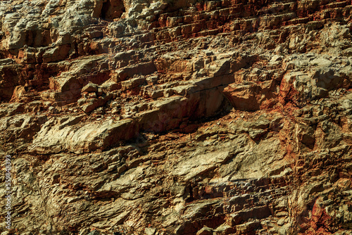 Grungy cragged bumpy pitted cavity stone facade, split layer gap.Ruined cracked shattered worn rough hiking canyon.Old ragged grunge steep marble cliff. Grand vintage crannied damaged impressive gorge