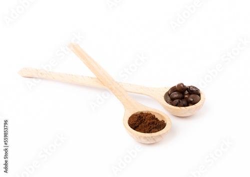 Ground coffee and coffee beans in wooden spoons isolated on white background.