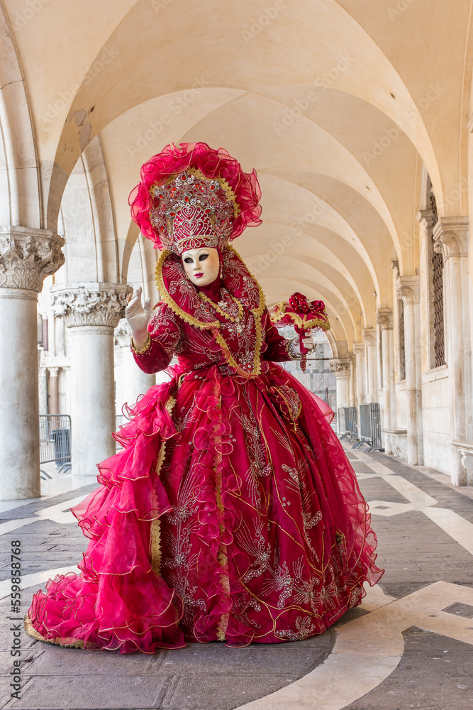 donna in costume di carnevale rosso, inserita in un sottoportico di palazzo ducale, figura intera, bouquet nella mano sinistra donna in costume di carnevale rosso, inserita in un sottoportico di palazzo ducale, figura intera, bouquet nella mano sinistra
