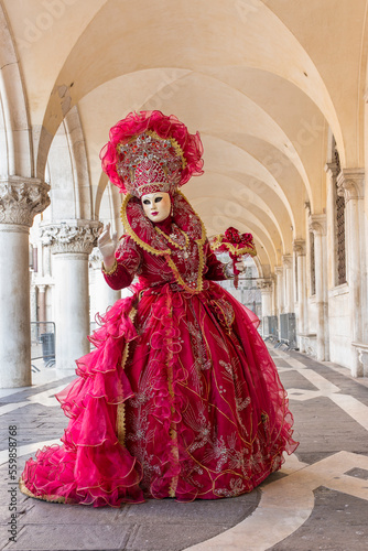 donna in costume di carnevale rosso, inserita in un sottoportico di palazzo ducale, figura intera, bouquet nella mano sinistra © frescofb
