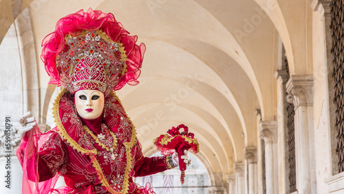 donna in costume di carnevale rosso, inserita in un sottoportico di palazzo ducale, taglio orizzontale photo