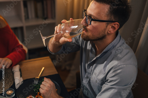 Foto Side view of a man having a sip of white wine