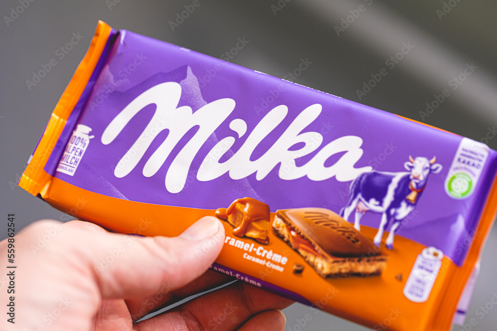 Milka. Uma pessoa segurando uma barra de chocolate Milka com recheio de ...