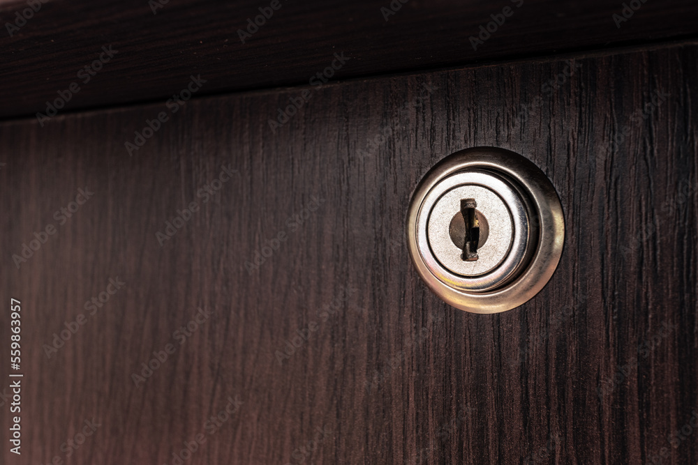 Small keyhole in a wooden box. Round lock in a wooden table. Keyhole on the door of a wooden cabinet Small keyhole in a wooden box. Round lock in a wooden table. Keyhole on the door of a wooden cabinet
