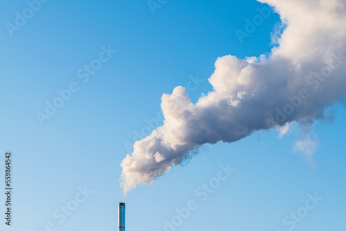 White smoke from the chimney in a blue sky.