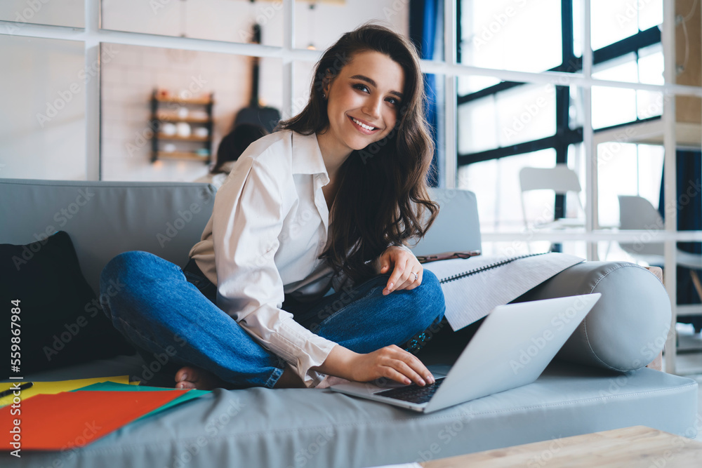 Glad designer using laptop on couch Glad designer using laptop on couch