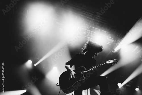 Silhouette of a guitar player. Guitarists perform on a concert stage. Dark background  smoke  concert spotlights.