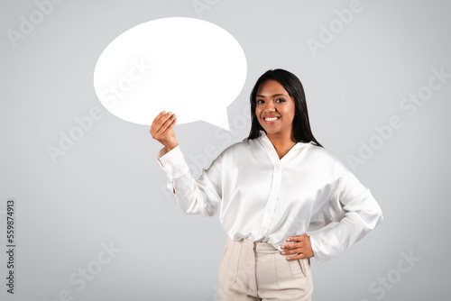 Happy confident millennial black businesswoman in white blouse hold abstract bubble, cloud for words and thoughts