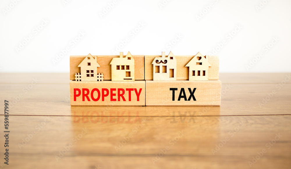 Property tax symbol. Concept words Property tax on wooden blocks. Beautiful wooden table white background. House models on wooden blocks. Business and property tax concept. Copy space. Property tax symbol. Concept words Property tax on wooden blocks. Beautiful wooden table white background. House models on wooden blocks. Business and property tax concept. Copy space.