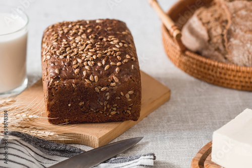 Fresh delicious whole grain rye bread with seeds close-up. Freshly baked bread on a wooden board. The context of a bakery with delicious bread. Confectionery products.