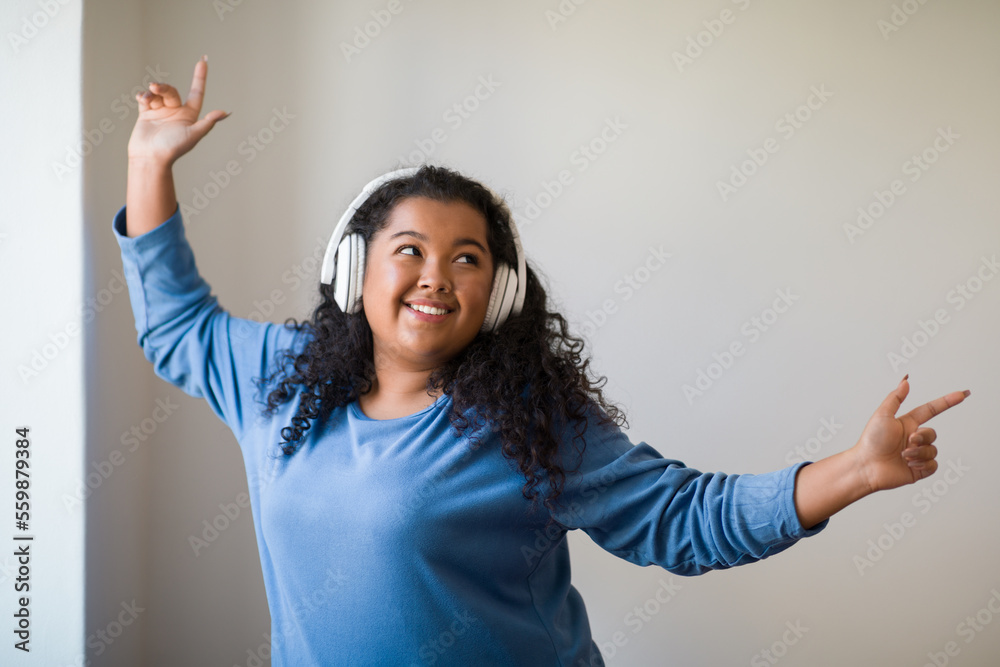Cute plus size woman dancing while spending weekend at home Cute plus size woman dancing while spending weekend at home