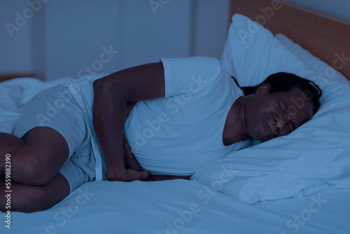 Nocturnal Panic Attack. Stressed Black Man Lying In Bed In The Night