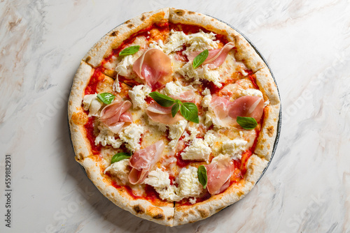 pizza with parma ham and cheese mozarella with basil on marble table top view photo