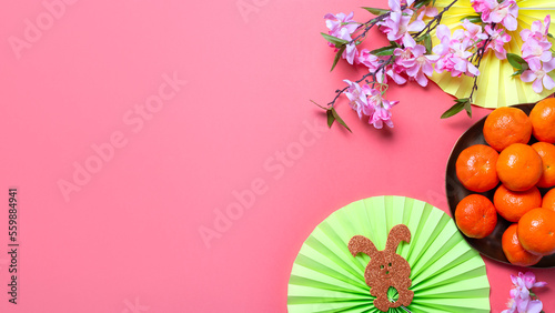 Chinese or lunar new year flat lay with paper decorations  mandarins and flowers on pink