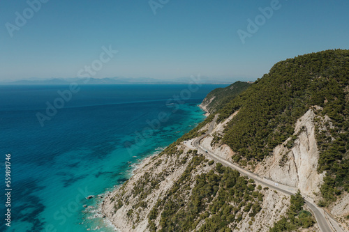 Seascape and sandy beach with turquoise clear waters and trees in Greece