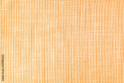 Natural linen texture as background. Cotton fabric with orange and white line striped pattern  texture close up  top vies  flat lay. Backdrop  wallpaper. Matereal for clothes  curtain and upholstery