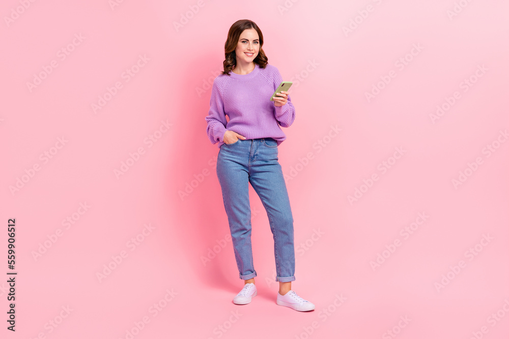 Full length photo of shiny cute lady wear violet sweater typing instagram twitter facebook modern device isolated pink color background Full length photo of shiny cute lady wear violet sweater typing instagram twitter facebook modern device isolated pink color background