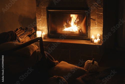 Photo Cozy burning fireplace and candles in dark evening room
