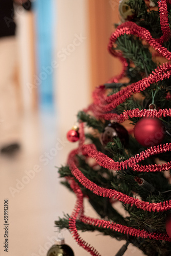 Red Christmas decoration on a pine tree on an interior domestic house scene