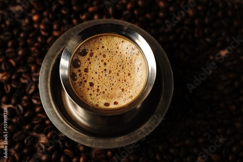 South Indian filter coffee served in steel cup and saucer, selective focus