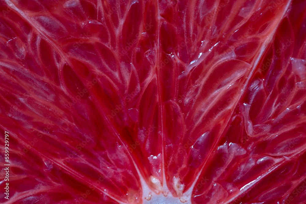 Closeup of sliced ripe grapefruit, macro. Red fresh grapefruit surface background or texture. Top view
