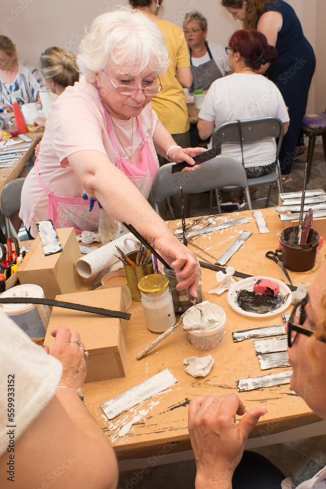 Women in an art workshop making decoupage boxes Women in an art workshop making decoupage boxes