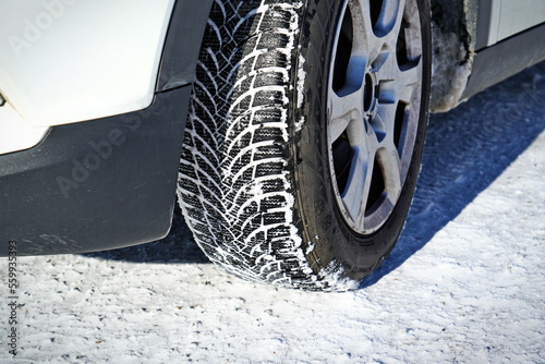 Driving car with winter tire wheel on snow road