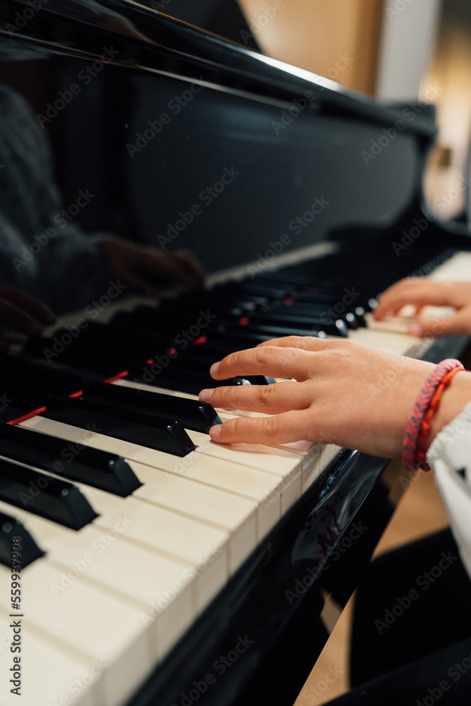 Obraz premium Close-up of the hands of a girl playing a grand piano 