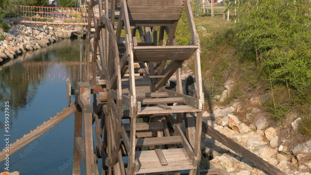 The wheel of a water mill stands on a stream in the summer in nature. The wheel of a water mill stands on a stream in the summer in nature.
