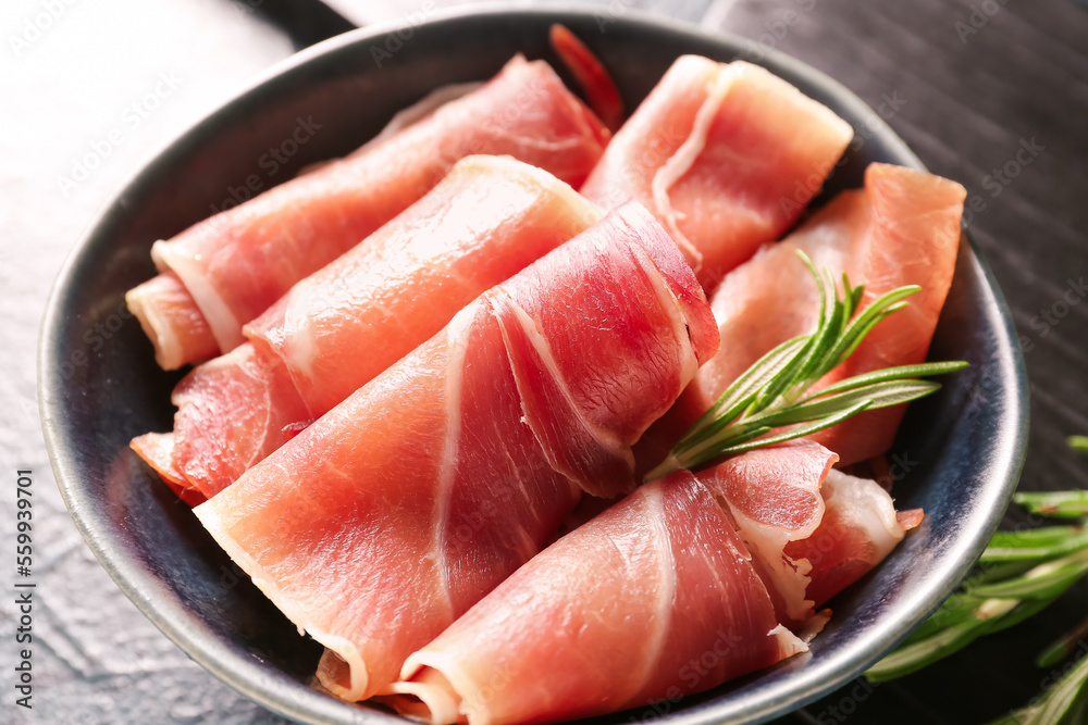 Bowl with rolled slices of tasty ham, closeup
