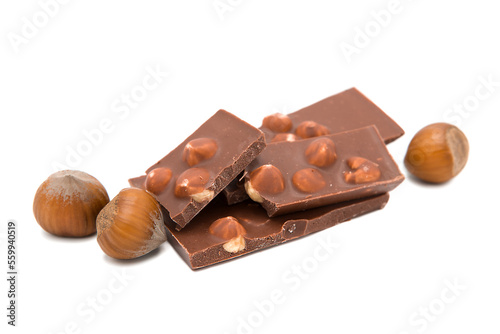 Pieces of milk chocolate with hazelnuts isolated on white background.
