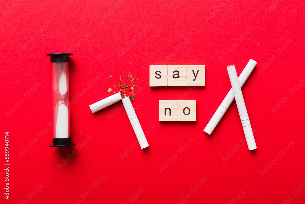 Cigarette And Wooden Blocks, Broken cigarette on table background with hourglass, No Tobacco Day with hourglass, clock health concept. time to quit smoking Cigarette And Wooden Blocks, Broken cigarette on table background with hourglass, No Tobacco Day with hourglass, clock health concept. time to quit smoking