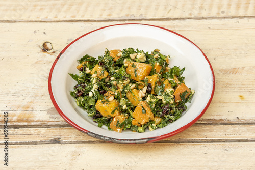 Cuadro en lienzo A plate with a healthy recipe for baked pumpkin salad with collard greens, raisi