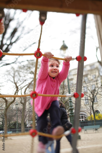 A two year-old girl plays at a children's playground in the Champs de Mars, Paris, France